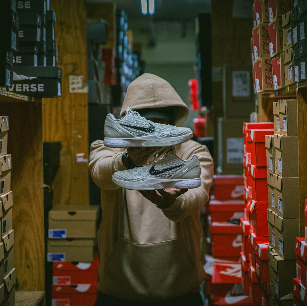 Mann in Sneaker Lager mit Nike Kobes in grau die in das Bild gehalten werden