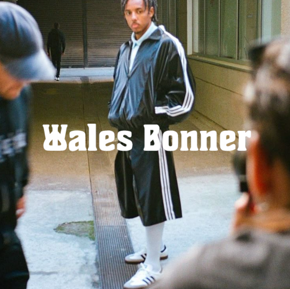 Person in einem retro-inspirierten Wales-Bonner-Trackset steht in einer urbanen Umgebung; im Vordergrund „Wales Bonner“-Schriftzug sichtbar.
