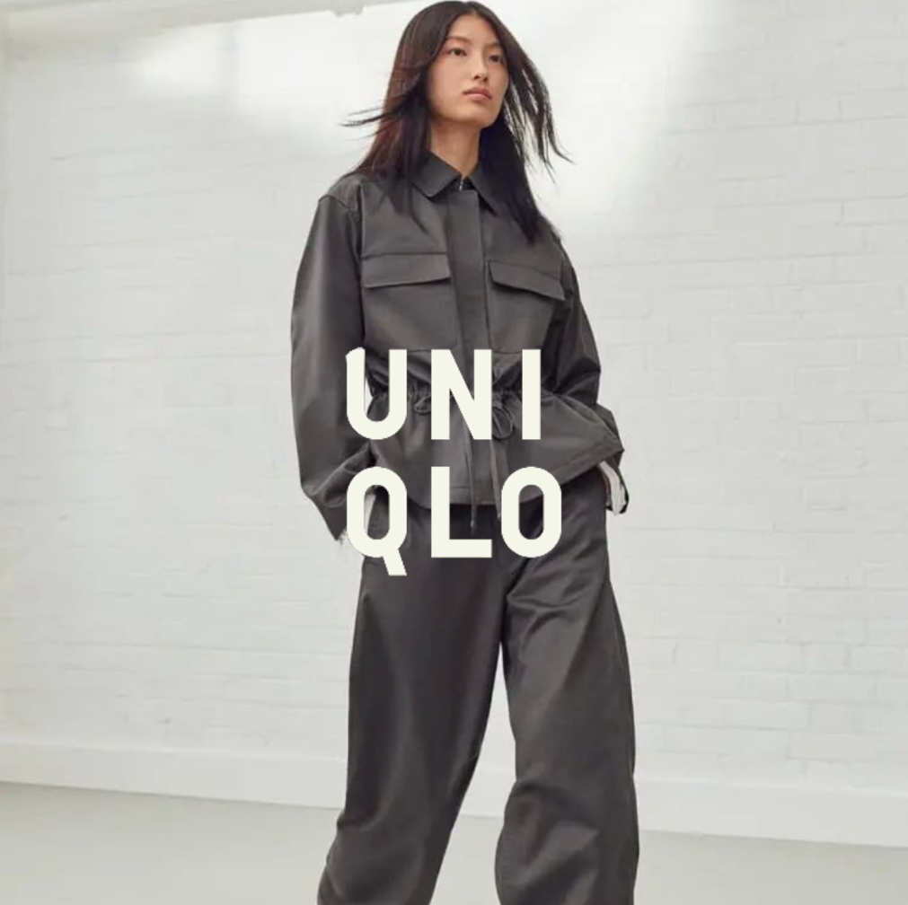 UNIQLO Logo, Mann in grauem Outfit post vor weißer Wand