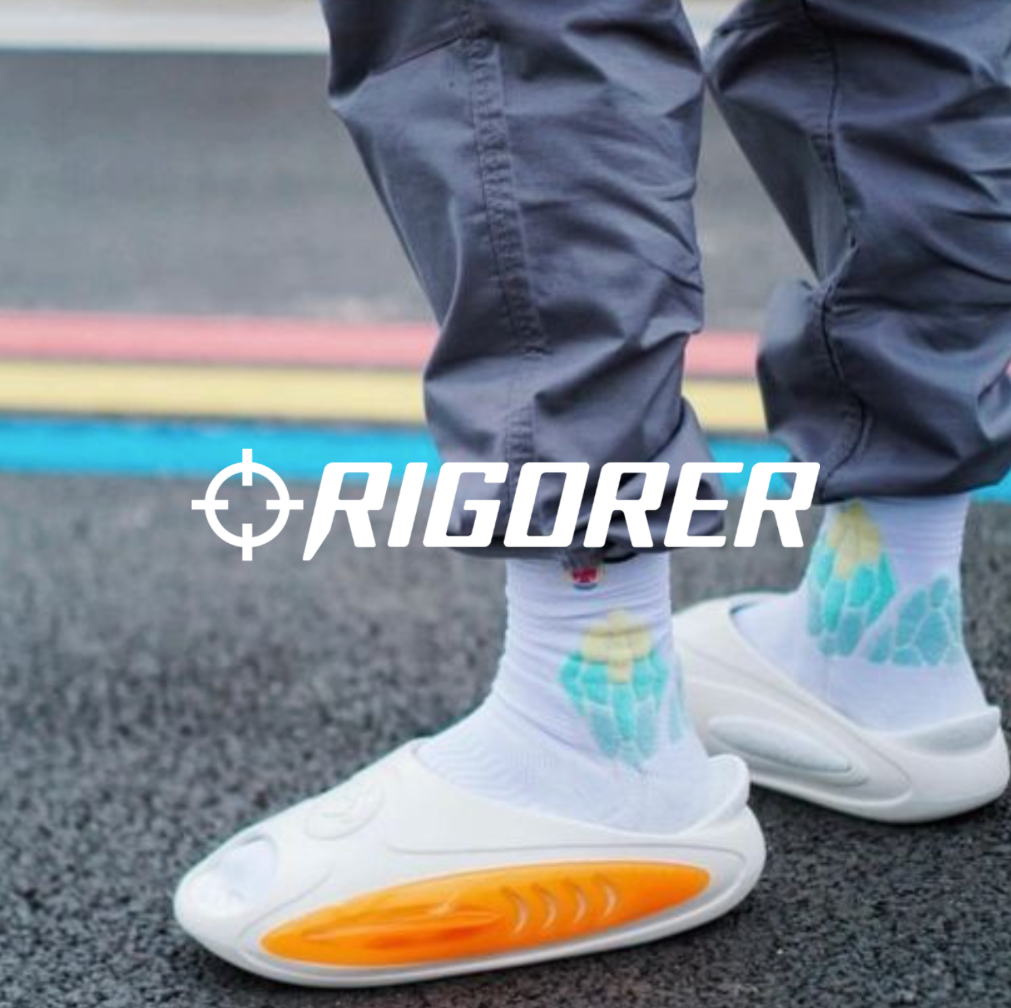 Rigorer Logo, Slipper mit bunten Soicken und schwarzer Hose mit geteerter Straße im Hintergund