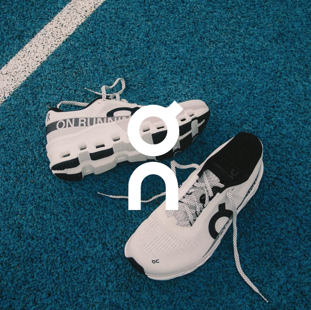 ON Logo, Wieße sneaker liegen auf einer blauen tartanbahn