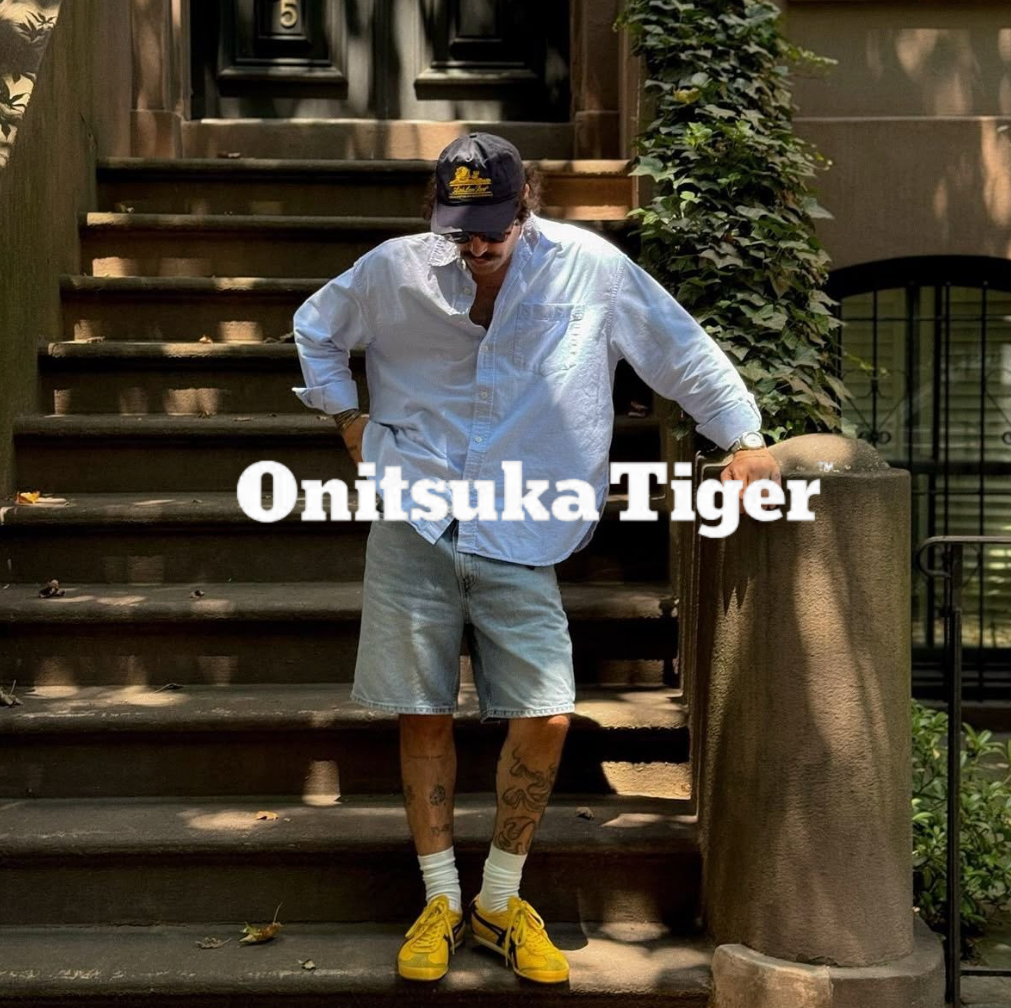 Onitsuka Tiger logo, Mann mit gelben sneakern, hemd und Shorts steht vor einem hauseingang