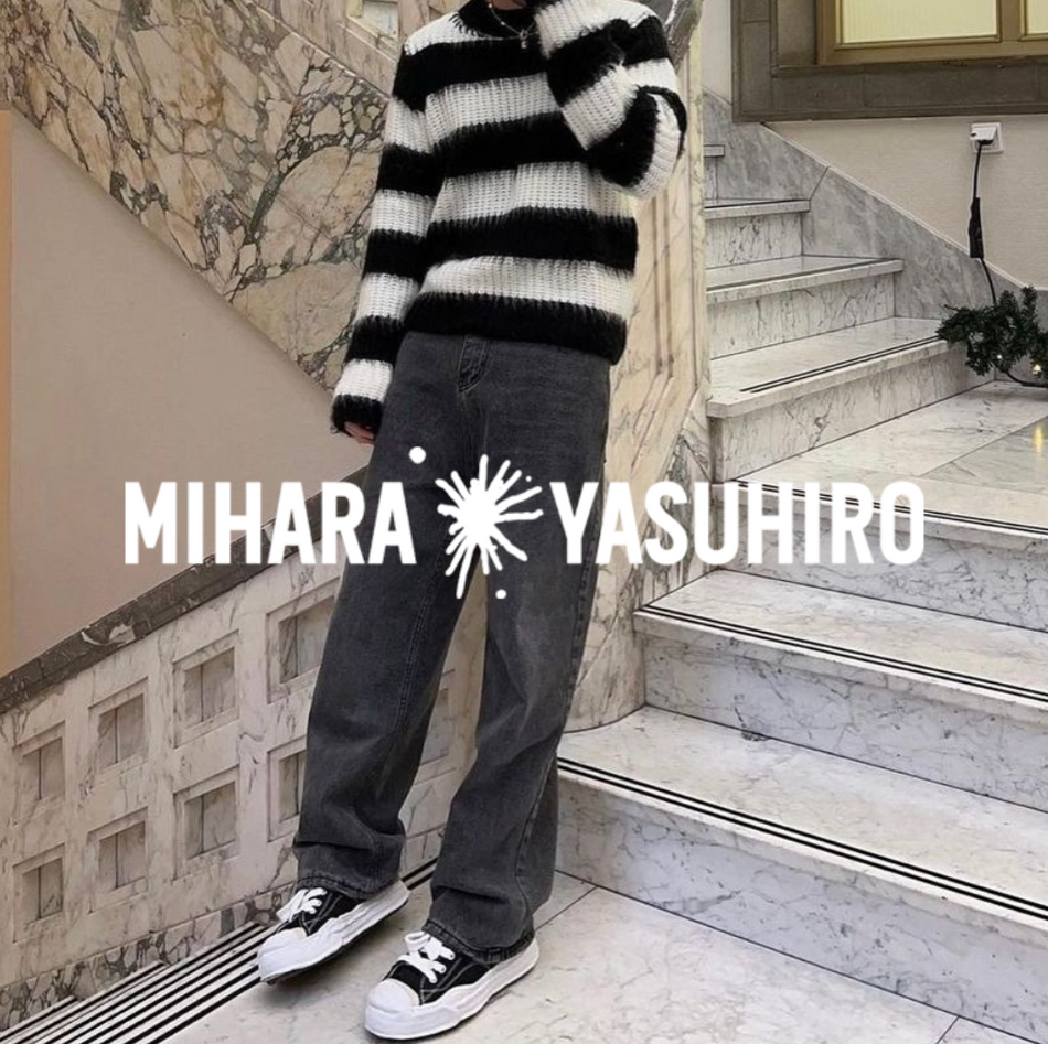 Mihara Yasuhiro Logo, mit Mann in Hank Sneakern, jeans und gestreiftem Sweater stehend in einem treppenaufgang