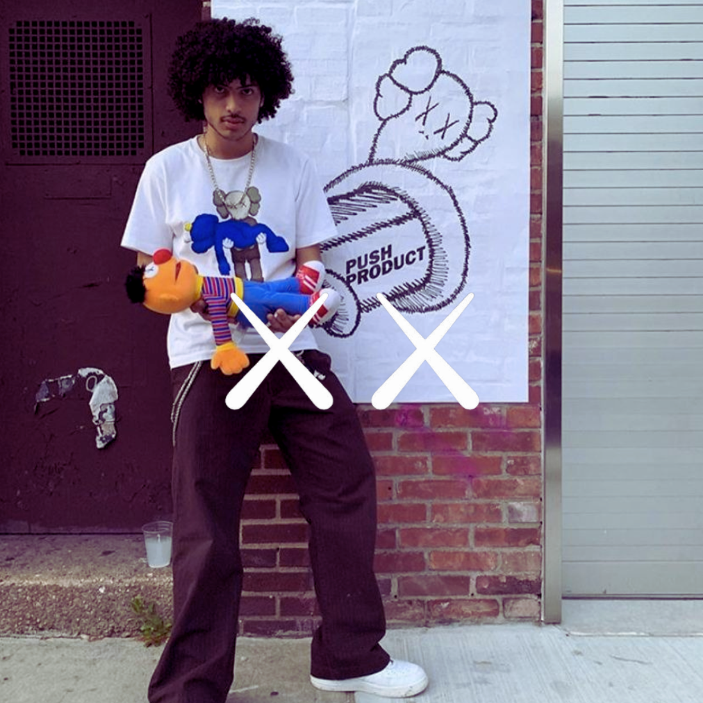 KAWS Logo, Mann mit schwarzer Jeans, weißem t Shirt und Sneakern vor urbanem Hintergund