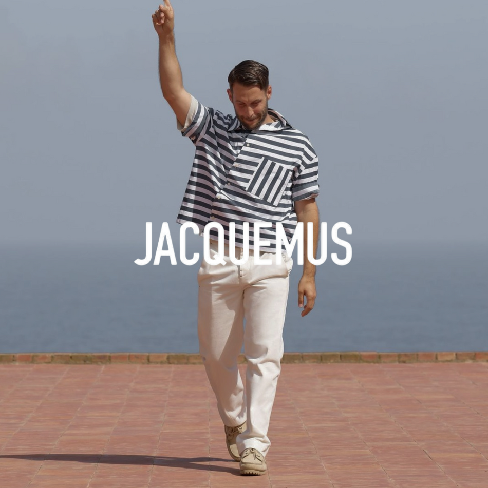 Jacquemus Logo, Männliches Model mit gestreiftem t Shirt und Gino Hose mit Meer im Hintergrund