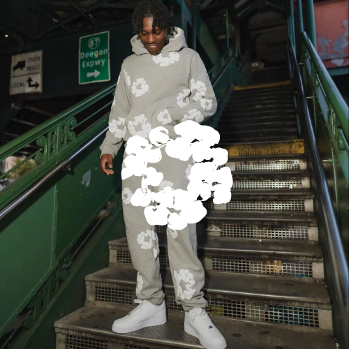 DENIM TEARS Logo mit Mann stehend auf Metro treppe in grauem Denim tears Tracksuit mit weißen Air Force 1 an.