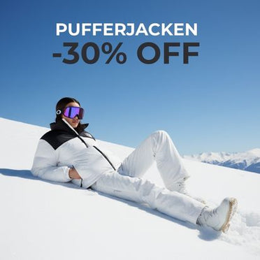 Pufferjacken -30 % Off, Frau in The North Face Jacke in schwarz weiß und weißer Hose liegend auf einer Schneepiste