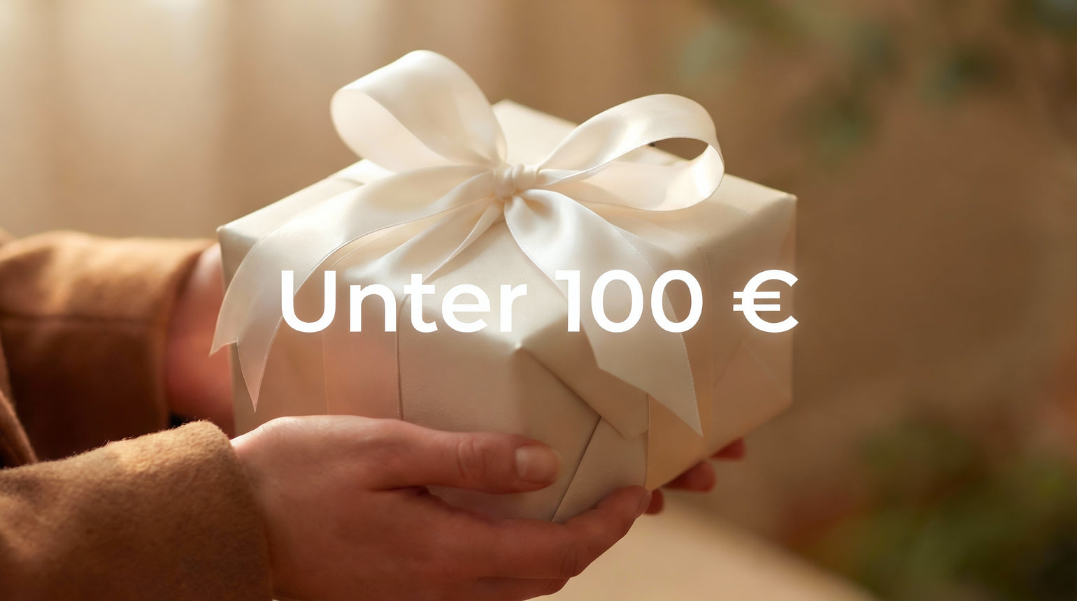 Unter 100 € Geschenke, ein Mann hält ein weiß eingepacktes Geschenk.